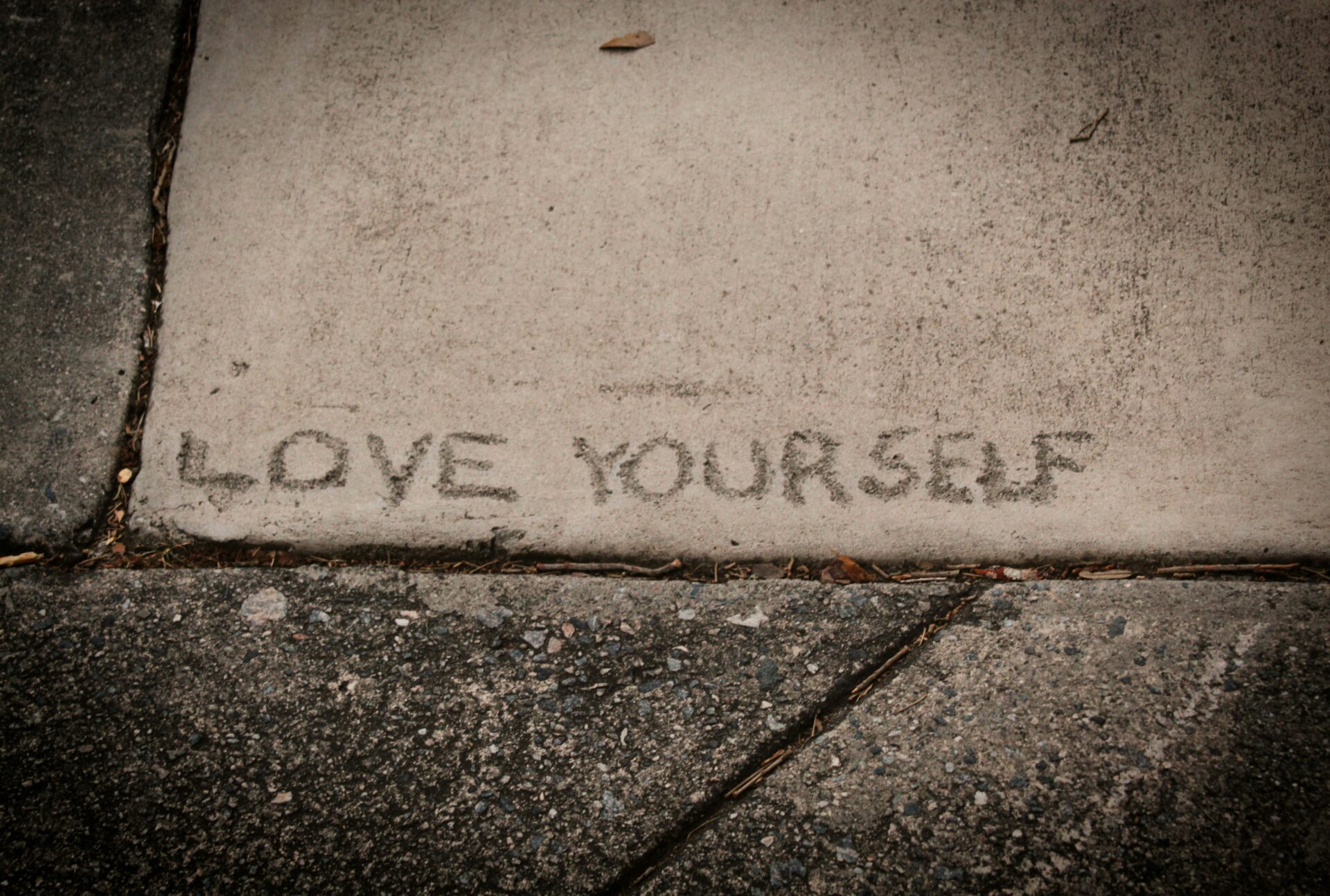 Schriftzug Love Yourself auf Beton, Design als Selbstfürsorge, Wanda Soul Studio