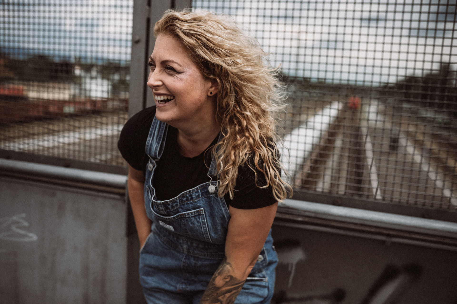 Susanne Bachl von Wanda Soul Studio lacht an einer Brücke, Blogbild