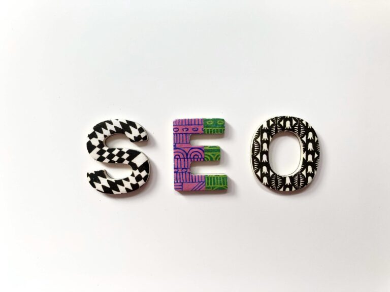 Schriftzug SEO aus bunten Perlen auf weißem Hintergrund